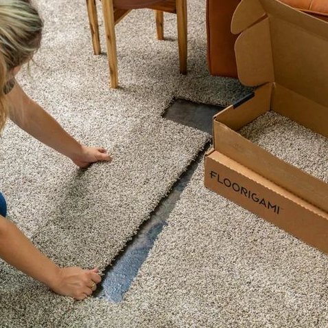 person installing carpet tiles